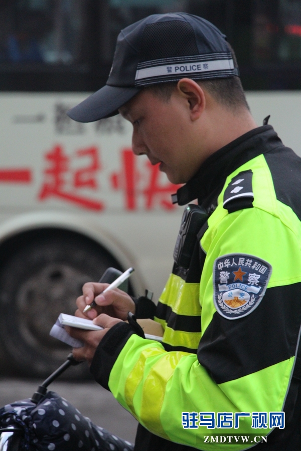 民警在核对罚款人身份证后，开出罚单.JPG