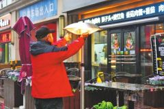 郑州一饭店门外放置电暖器 供行人、环卫工等取暖
