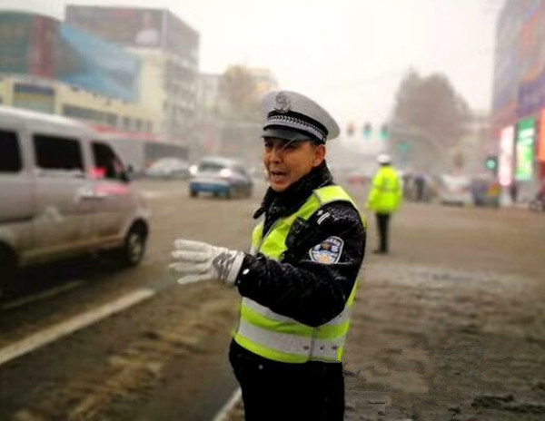 驻马店迎今年首场雪 交警在风雪中站成“雪警”（图）