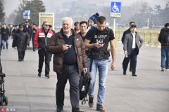 北京春意来袭 中外游客解外衣享春光游览天安门