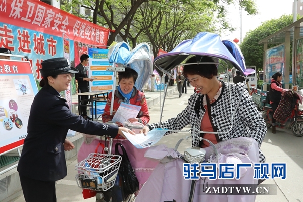 图为民警向过往群众发放宣传页.JPG