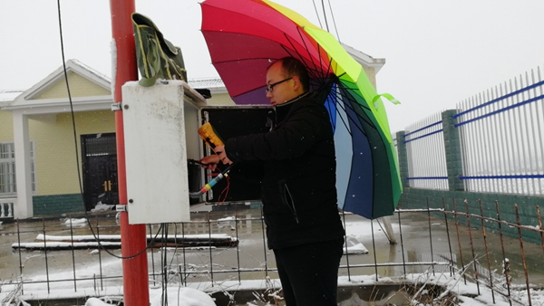 正阳县气象站设备保障人员冒雪抢修设备 