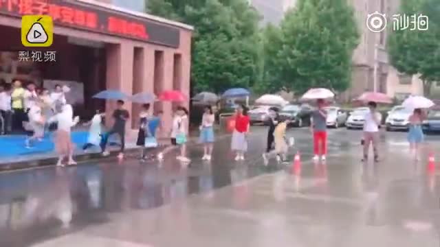 小升初考试遇大雨 老师搭30米伞桥护送学生