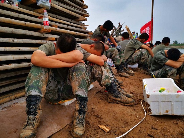 决口封堵抢险，救灾官兵累到坐着睡着