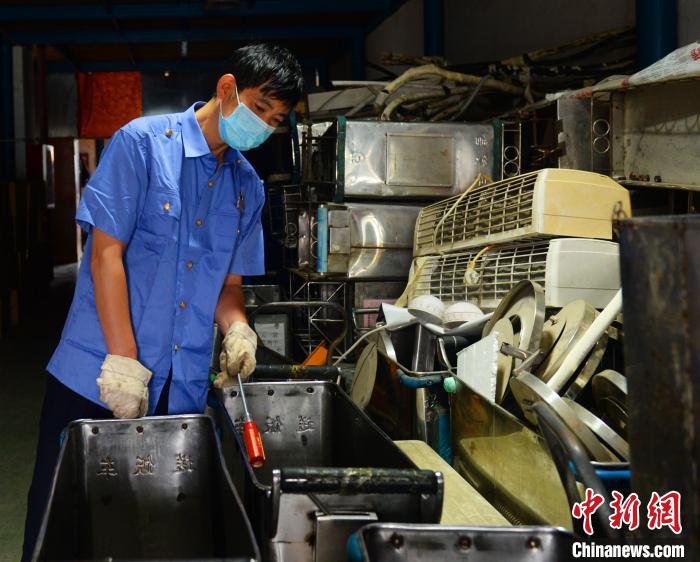 图为刘发军正在挑选修理后可再次使用的物件。　黄昆 摄