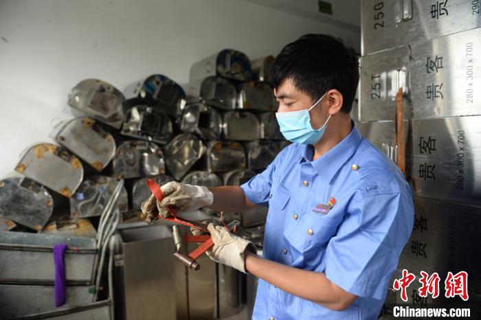 图为刘发军点取通过修理能再次使用的消防安全锤。　黄昆 摄