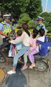 暑假来临交警严查电动车违法载人