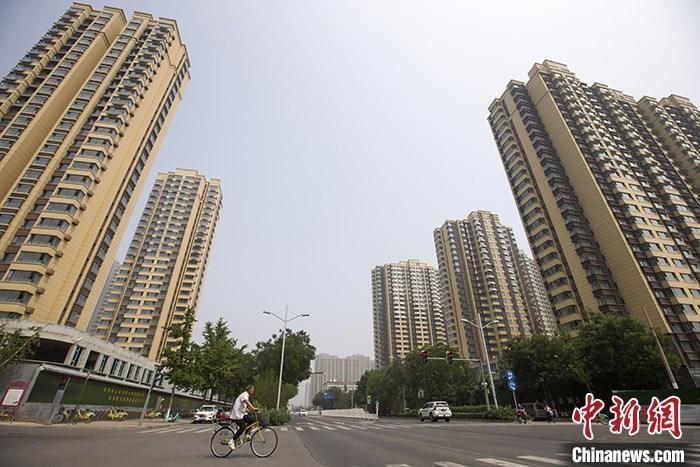 资料图：市民从一楼盘前经过。 <a target='_blank' href='http://www.chinanews.com/'>中新社</a>记者 张云 摄