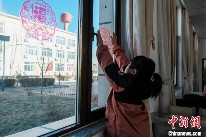 图为戍边民警的孩子在贴新年窗花。　江飞波 摄