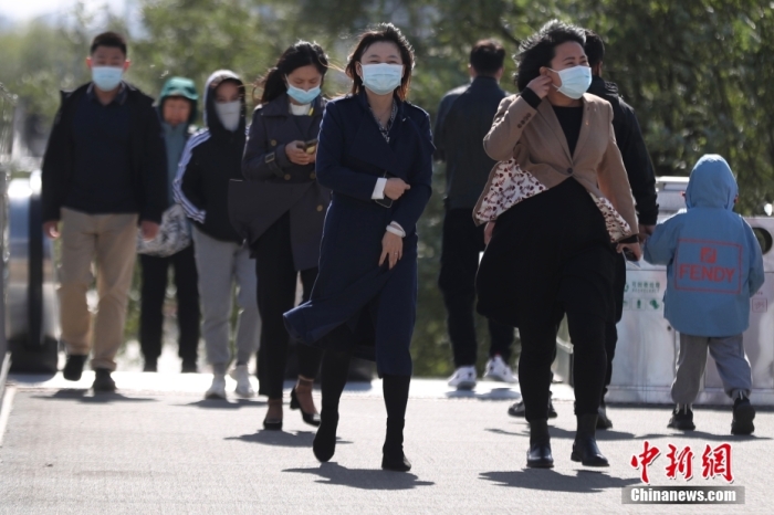 资料图：市民在大风降温天气中出行。 <a target='_blank' href='/'>中新社</a>记者 蒋启明 摄