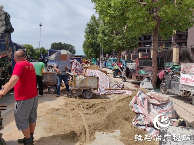 巨源城小区装修材料堆在路边 过往市民不解：这不是条公共道路吗?