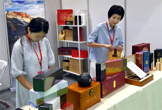 9月6日，在农加会脱贫地区和革命老区特色农产品展厅，四川荥经县展区的工作人员在整理参展商品。王颂 摄.jpg