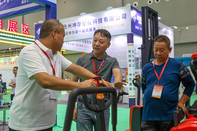 9月6日，在中国农加会F展厅农产品加工机械装备展区，观众与客商交谈。何五昌 摄.JPG